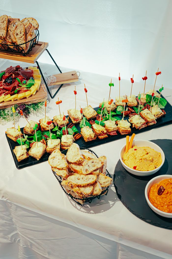 our-story Delicious assortment of sandwiches and dips on a buffet table, perfect for events.