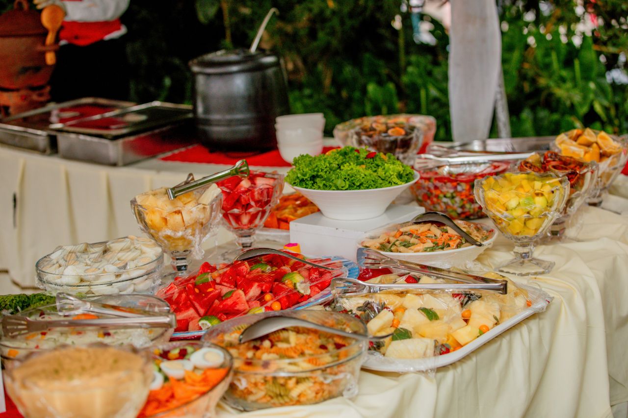 heros-img Colorful assorted dishes on an outdoor buffet table ready to serve at a gathering.