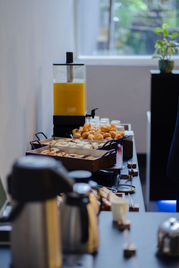 services-03 A sophisticated buffet setup featuring coffee, pastries, and juice in a modern dining setting.